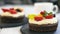 Chocolate cupcakes with cream cheese, fruits and berries. Mini cake as healthy coffee dessert. Closeup, selective focus