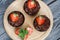 Chocolate cupcakes with strawberries and mint. The berries are cut in half. Close-up shot