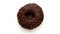 Chocolate donut turns around on white background, top view