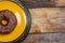 Chocolate donut on a yellow plate on a pink background