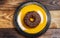 Chocolate donut on a yellow plate on a pink background