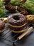 Chocolate donuts sprinkled with crushed nuts on a black table