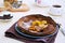 Chocolate Dutch Baby pancake with caramelized bananas on a gray plate on a light concrete background. Selective focus. American