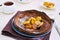 Chocolate Dutch Baby pancake with caramelized bananas on a gray plate on a light concrete background. Selective focus. American