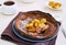 Chocolate Dutch Baby pancake with caramelized bananas on a gray plate on a light concrete background. Selective focus. American