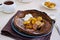 Chocolate Dutch Baby pancake with caramelized bananas on a gray plate on a light concrete background. Selective focus. American