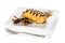 Chocolate eclairs with cream filling on a platter isolated