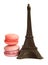 Chocolate Eiffel Tower and two macarons on white background