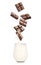 Chocolate falling into glass with milk on white background
