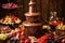 chocolate fountain with warm liquid chocolate flowing over fresh fruits and pastries