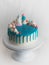 chocolate frosted blue dripped icing white cup cake, unicorn , meringue and sprinkles on top