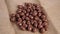 Chocolate glazed nut balls fall in a heap on a rustic burlap.