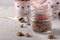 Chocolate Granola crispy muesli with natural honey and nuts in a glass jar against a gray background, Closeup