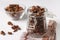 Chocolate Granola crispy muesli with natural honey and nuts in a glass jar and bowl against a white background, healthy food,