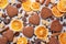 Chocolate heart cookies, oranges cinnamon and spicy spices on a gray table, top view, close up