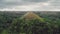 Chocolate Hills aerial view: mountains with high trees and rain clouds on spring day, natural wonder