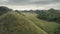 Chocolate Hills closeup aerial view: green peaks with grass, mosses and trees in misty haze