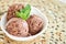 Chocolate ice cream with mint leafe. three balls in a white bowl on a vintage table.