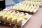 Chocolate, lemon, vanilla and strawberry cheesecakes stand in a row on mirrored trays