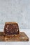 Chocolate marbled cake biscuit Zebra with chocolate icing on a wooden board on a gray background.