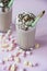 Chocolate milkshake with ice cream and whipped cream, marshmallows, cookies, waffles, served in a glass cup. Light background