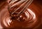 Chocolate. Mixing melted dark chocolate with a whisk. Closeup of liquid hot chocolate swirl