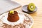 Chocolate Moelleux cake or molten cake, with kiwi fruit, over a wooden background