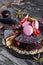 Chocolate mousse cake with mirror glaze decorated with macaroons, figs, flowers on dark rustic background. Holiday cake