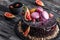 Chocolate mousse cake with mirror glaze decorated with macaroons, figs, flowers on dark rustic background. Holiday cake