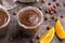 Chocolate mousse with cream, hazelnuts and orange in glasses on wooden table