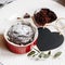 Chocolate muffin in red cup. Mockup valentine black heart copyspace. Small glazed ceramic ramekin with brown cake on a white