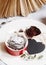 Chocolate muffin in red cup. Mockup valentine black heart copyspace. Small glazed ceramic ramekin with brown cake on a white