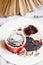 Chocolate muffin in red cup. Mockup valentine black heart copyspace. Small glazed ceramic ramekin with brown cake on a white