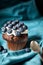 Chocolate muffin with soft cream and fresh blueberry, dark rustic background