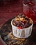 Chocolate muffin with topping, jam and crumbled cookies on wooden dark maroon background, copy space. Homemade bakery concept