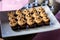 Chocolate muffins with cream on plate, close-up. Cupcakes at the banquet, sweet table