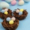 Chocolate nests filled with Easter eggs on blue