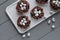 Chocolate nests with sweet eggs on gray wooden background