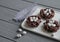 Chocolate nests with sweet eggs on gray wooden background