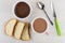 Chocolate paste, pieces of bread, spoon, knife on wooden table