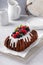 Chocolate pound cake topped with cream cheese glaze and berries