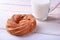 Chocolate and powdered sugar cream puff rings and glass with milk on wooden table. traditional Breakfast.