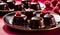 chocolate pralines glistening with a glossy with raspberry, plate of chocolates and raspberries ,pralines background