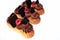 Chocolate and raspberry eclairs with chocolate decorations and fresh berries