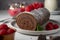 Chocolate roll cake or swiss dessert cake with raspberries. Romantic mood with candles