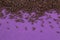 Chocolate sprinkles raining down on purple background - abstract celebration invitation background