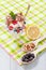 Chocolate and white ice cream in a glass with raspberry and currant berries and mint leaves on checkered napkin