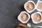 Chocolate yogurt cups on dark mottled background with small silver spoons - Three chocolate flavoured yoghurt cups with foil lid