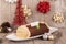 Chocolate yule log cake with Christmas decorations disposed on wooden table.