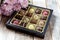 Chocolates in a box on the table. Gift wrap. Wooden background. Close-up. Place for your text.